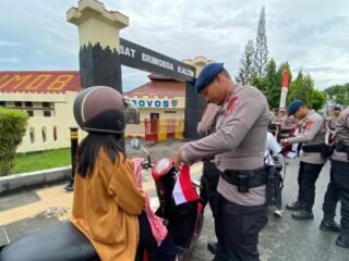 Brimob Polda Kaltim Turun ke Jalan, Bagikan Ribuan Bendera
