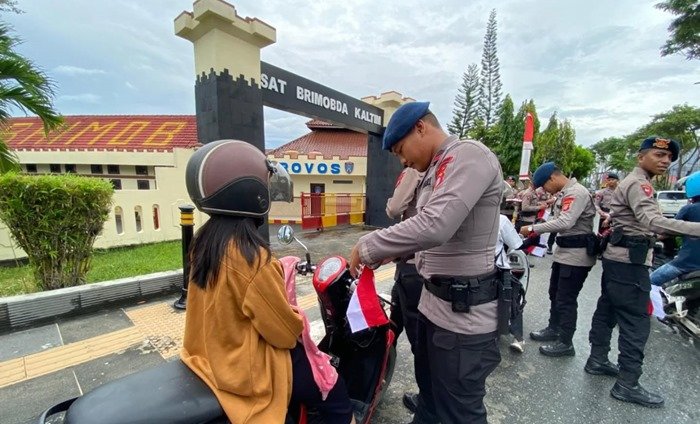 Brimob Polda Kaltim Turun ke Jalan, Bagikan Ribuan Bendera